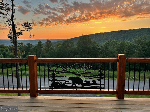 deck at dusk with a water and mountain view