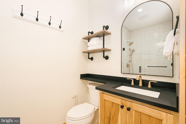 bathroom with walk in shower, vanity, and toilet