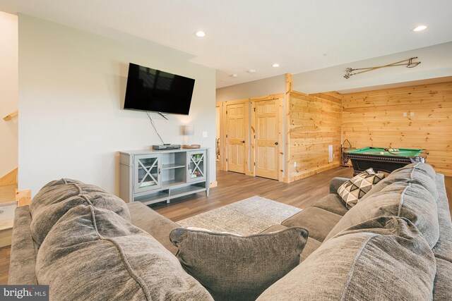 living room featuring wood-type flooring, billiards, and wood walls