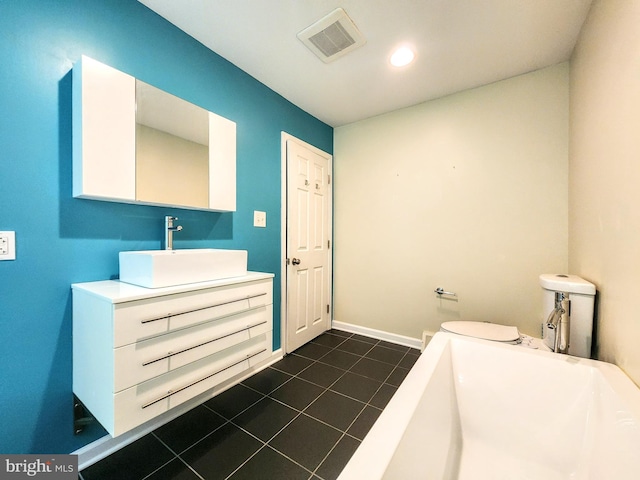 bathroom featuring tile patterned flooring, vanity, toilet, and a bathing tub