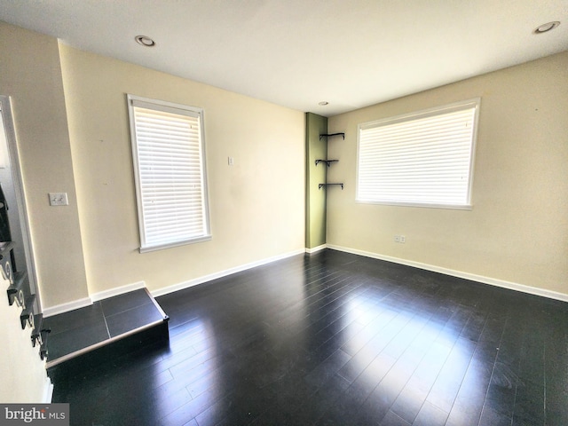 spare room with dark hardwood / wood-style flooring