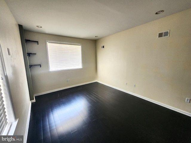 unfurnished room with dark wood-type flooring