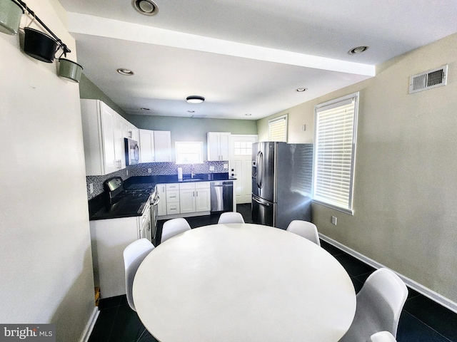 kitchen featuring white cabinetry, dark tile patterned floors, stainless steel appliances, and sink