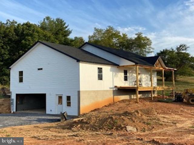 view of home's exterior with gravel driveway and a garage