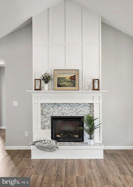 details with baseboards, wood finished floors, and a fireplace