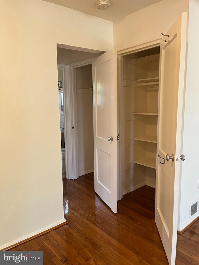 unfurnished bedroom with a closet and dark wood-type flooring