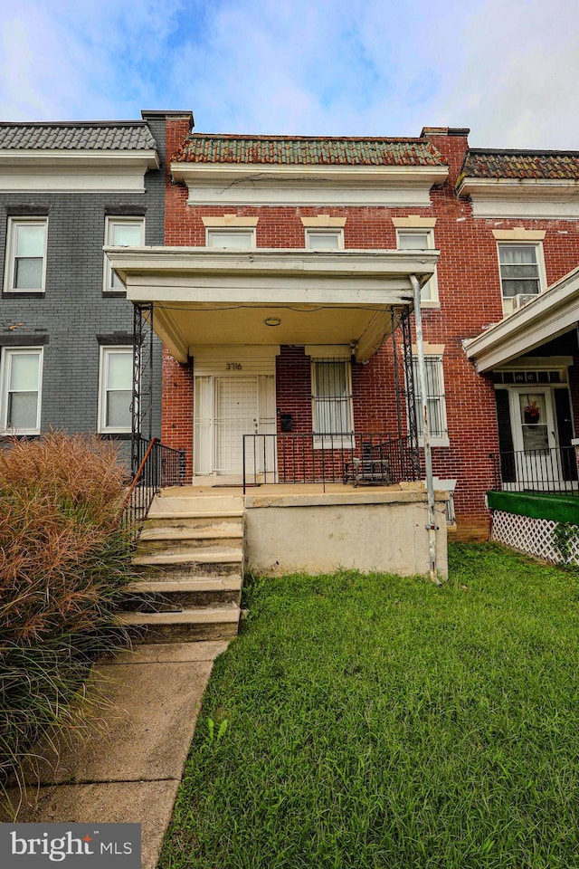 view of front of property with covered porch and a front lawn