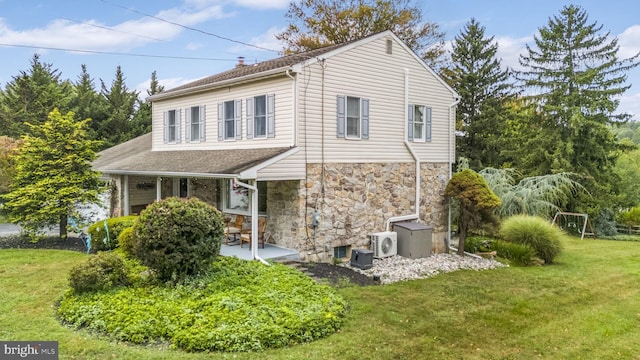 view of front of house with ac unit and a front lawn