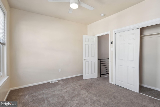 unfurnished bedroom with carpet, a closet, and ceiling fan