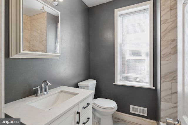 bathroom featuring plenty of natural light, vanity, and toilet