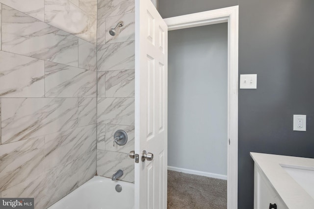 bathroom with tiled shower / bath combo and vanity