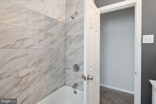 bathroom featuring tiled shower / bath and vanity