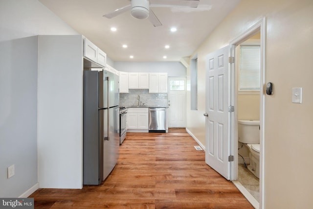 kitchen featuring ceiling fan, stainless steel appliances, light hardwood / wood-style floors, and white cabinetry