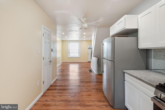 kitchen with ceiling fan, white cabinetry, stainless steel appliances, and wood-type flooring