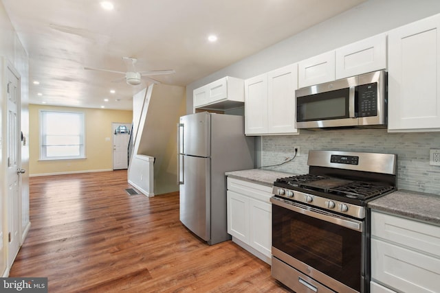 kitchen featuring stainless steel appliances, light wood-type flooring, ceiling fan, and white cabinets