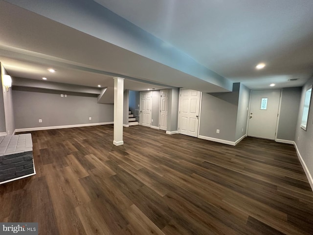 basement with dark hardwood / wood-style floors