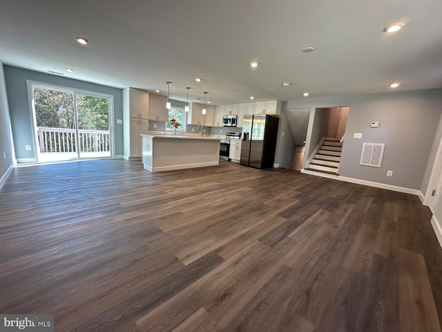 unfurnished living room featuring dark hardwood / wood-style flooring and sink