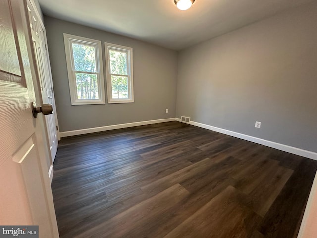 spare room with dark hardwood / wood-style floors