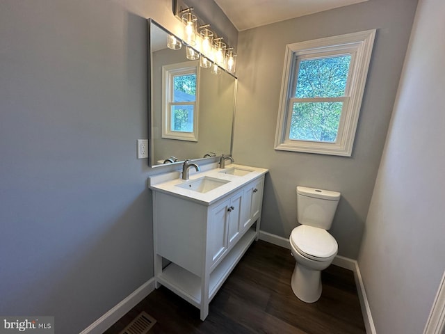 bathroom featuring wood-type flooring, vanity, and toilet