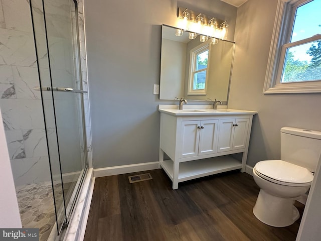 bathroom featuring walk in shower, vanity, a wealth of natural light, and toilet