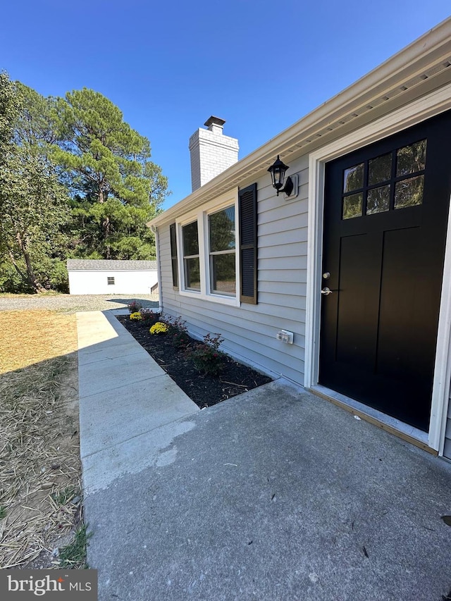 view of exterior entry with a patio