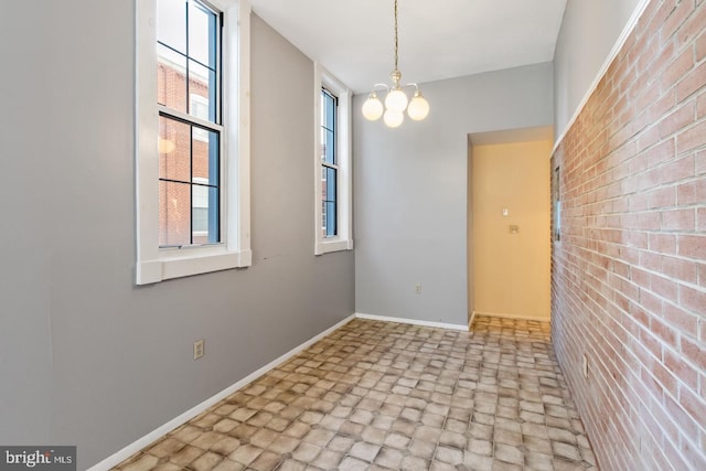 unfurnished dining area with brick wall and an inviting chandelier