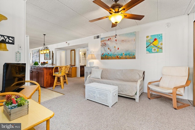 living room featuring carpet flooring, a ceiling fan, and visible vents