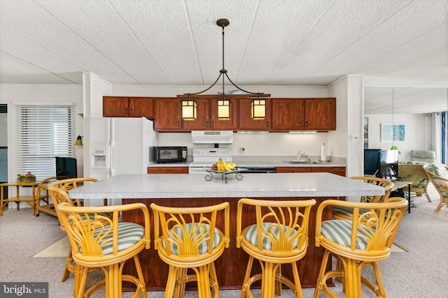 kitchen with light countertops, carpet floors, exhaust hood, white appliances, and a sink