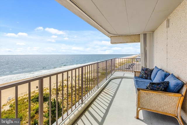 balcony featuring a view of the beach and a water view