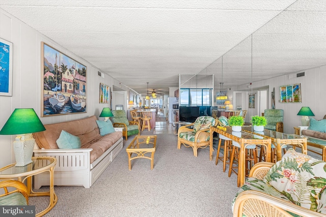 carpeted living area featuring visible vents and ceiling fan