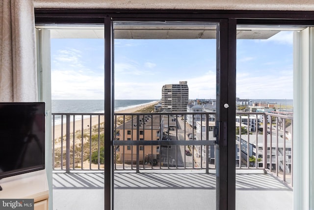 balcony featuring a view of the beach and a water view