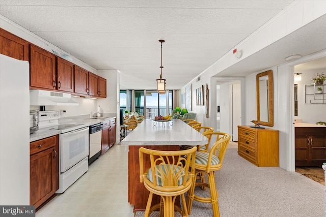 kitchen featuring a textured ceiling, white appliances, pendant lighting, light carpet, and a center island