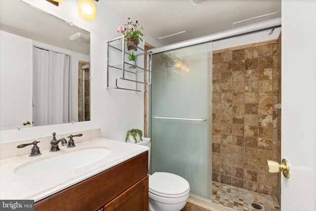 bathroom featuring vanity, a shower stall, and toilet