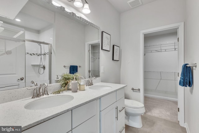 bathroom with walk in shower, vanity, and toilet