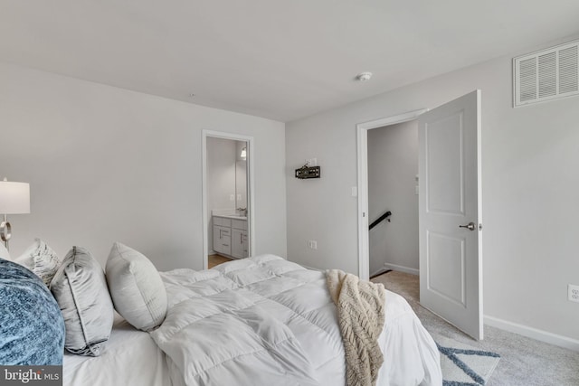 bedroom featuring light carpet and ensuite bathroom