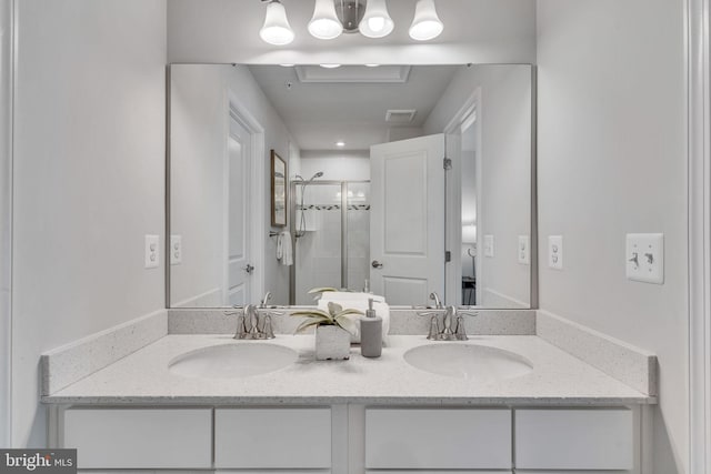 bathroom featuring a shower with door and vanity