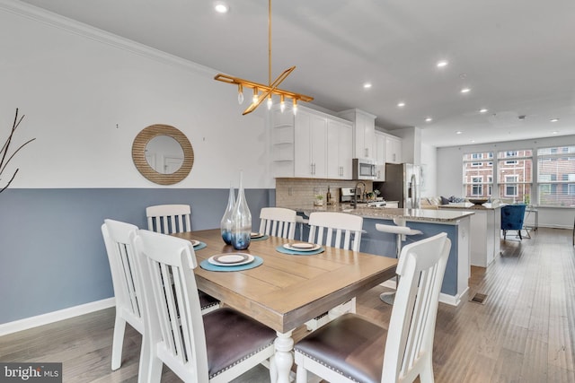 dining space featuring ornamental molding and hardwood / wood-style flooring