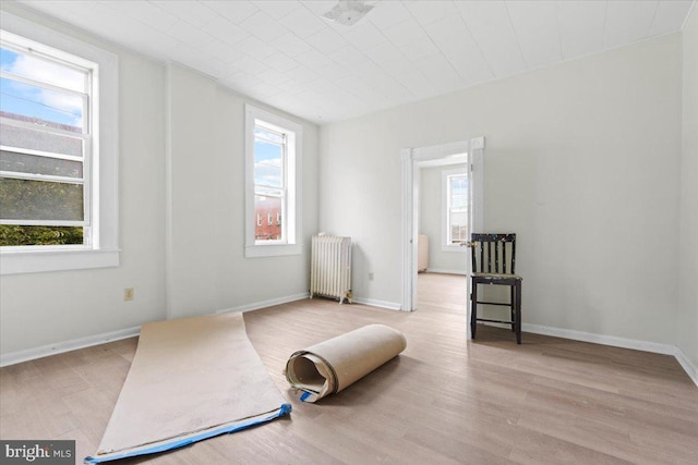 sitting room featuring light hardwood / wood-style floors, radiator, and a wealth of natural light