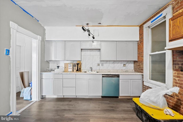 kitchen with stainless steel dishwasher, brick wall, dark wood-type flooring, and white cabinetry