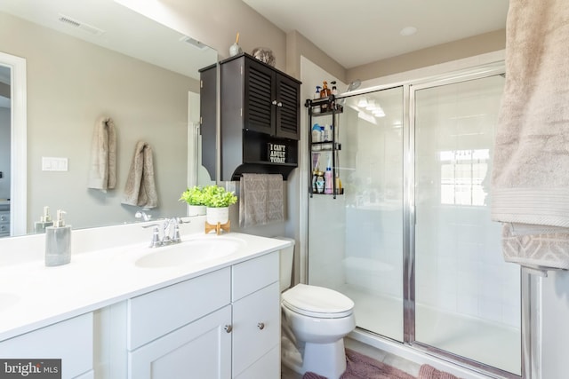 bathroom with vanity, toilet, and an enclosed shower