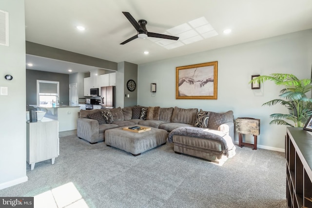 carpeted living room with ceiling fan