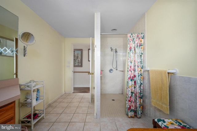 bathroom featuring curtained shower, tile patterned flooring, and tile walls