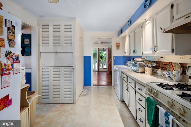 kitchen featuring white cabinets, independent washer and dryer, white appliances, and ventilation hood