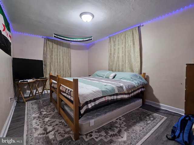 bedroom featuring a textured ceiling and dark hardwood / wood-style floors