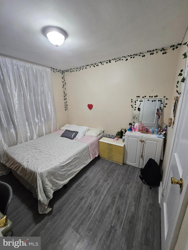 bedroom with dark hardwood / wood-style floors