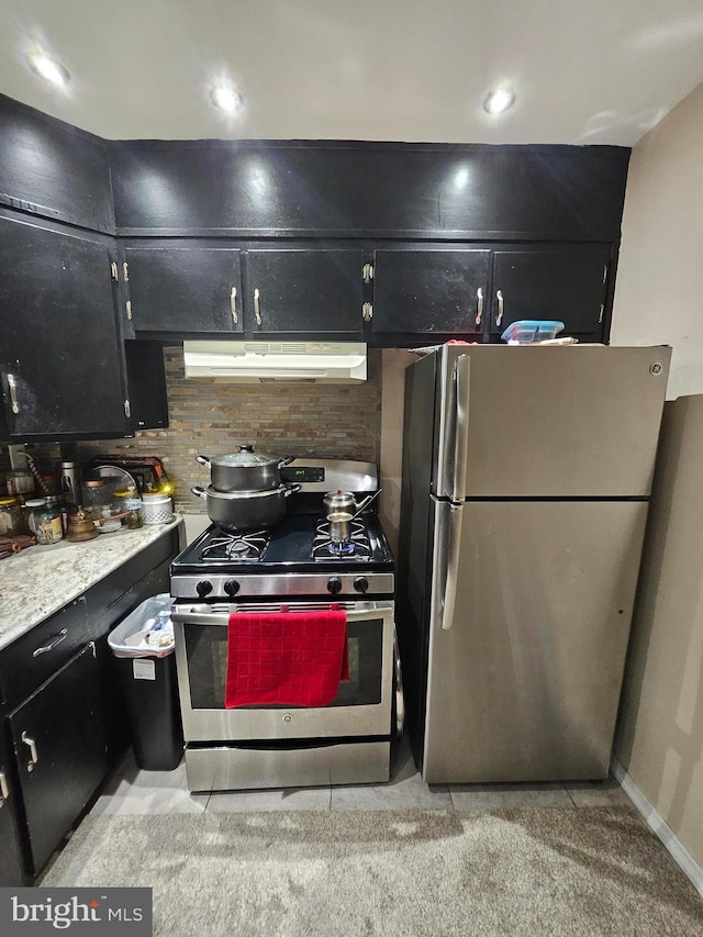 kitchen with light colored carpet, stainless steel appliances, and backsplash