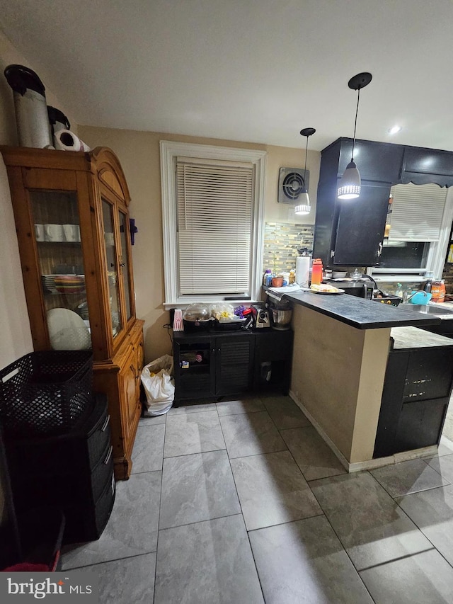 kitchen featuring kitchen peninsula, backsplash, and tile patterned flooring