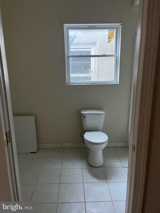 bathroom with tile patterned floors, toilet, and baseboards