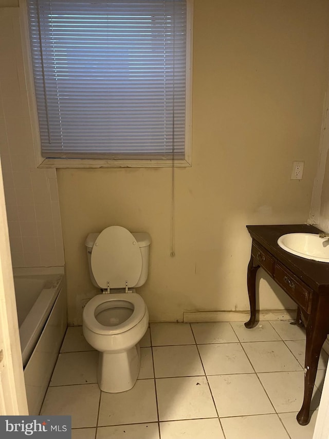 full bathroom with tile patterned floors, a bathing tub, toilet, and a sink