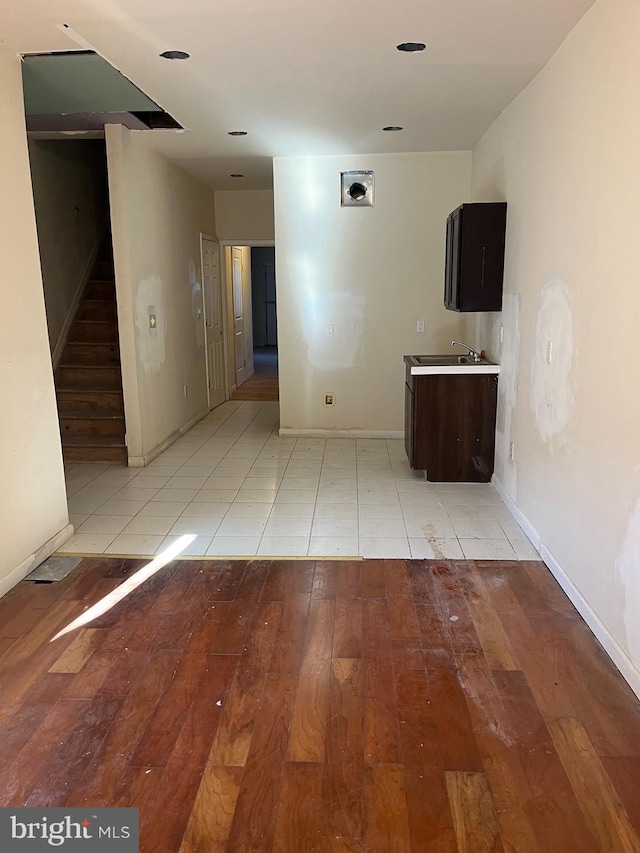 corridor featuring stairway, baseboards, and light wood-style flooring